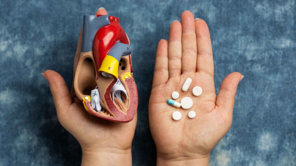 Heart failure medications in Thrissur concept showing heart model and pills in hand